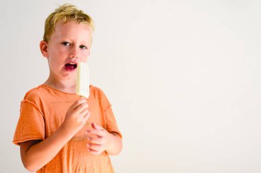 Sevimli çocuk beyaz arka planda bir dondurma yemek.