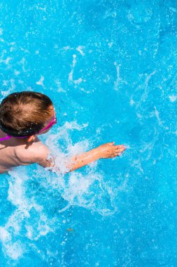 Yaz aylarında bir havuz serin su sıçramasına çocuk