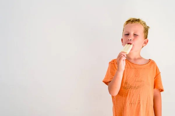 Niedlicher Junge Isst Ein Eis Vor Weißem Hintergrund — Stockfoto