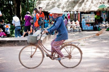 Angkor Wat, Kamboçya - 30 Ekim 2011:Cambodian kadın bir köy yoluyla bir bisiklet sürme.