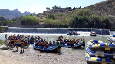 Murcia, İspanya - 22 Temmuz 2018: Grup üzerinde büyük hava ile şişirilen kayıklar sakin bir nehirde Rafting pratik birçok insan