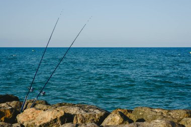 Balıkçılık çubuklar olmadan Balıkçılar deniz kıyısından kayalar için sabit