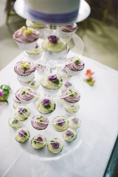 Desserts and wedding cake with very sweet cupcakes at an event.