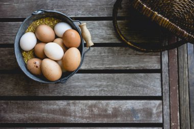 Kova tavuk yumurtası ve hasır sepet dolu.