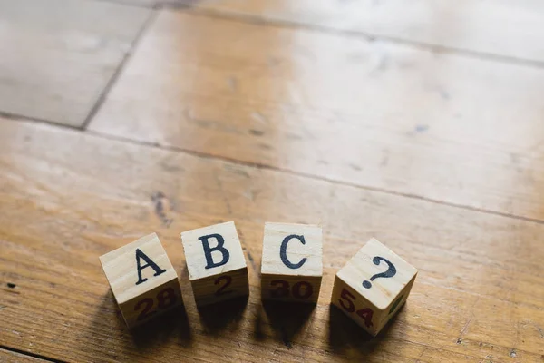 Wood dice with letters abc and interrogation.