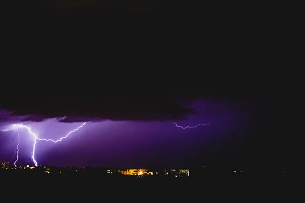 Rays in a night storm with light and clouds.