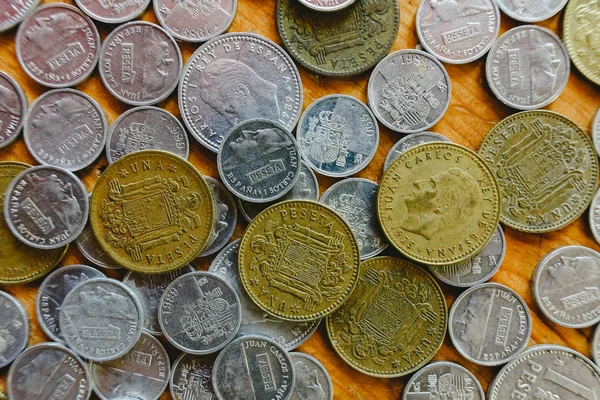 Group of old Spanish coins on wooden floor.