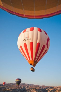 Göreme, Türkiye - 4 Nisan 2012: sıcak hava balonları kaya oluşumları üzerinde güneş doğarken Kapadokya vadisi uçan turistler için.
