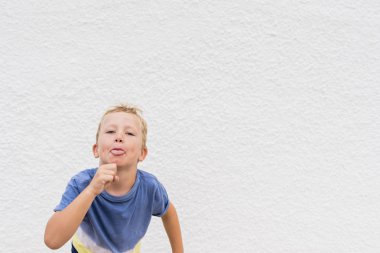 Sarışın çocuk beyaz arka plan üzerinde komik surat.