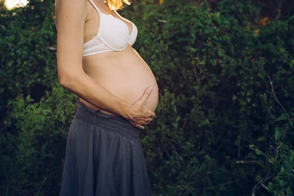 Zbliżenie Kobieta Ciąży Brzuch Głaszcząc Nią Ręce Naturze — Zdjęcie stockowe