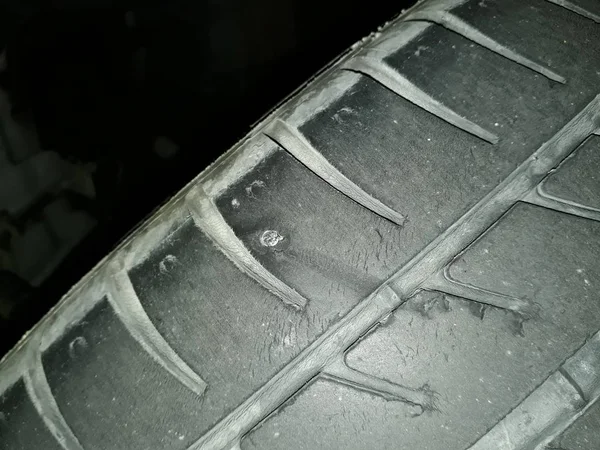 Puncture in a car wheel due to a nail.