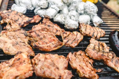 Yukarıda da görüleceği bir barbekü üzerinde sosis, domuz ve tavuk kavrulmuş.