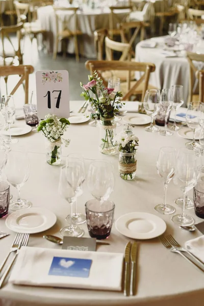 Centerpieces in a wedding hall, floral decorations photographed during the day.