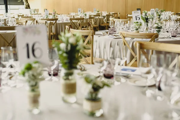 Centerpieces in a wedding hall, floral decorations photographed during the day.