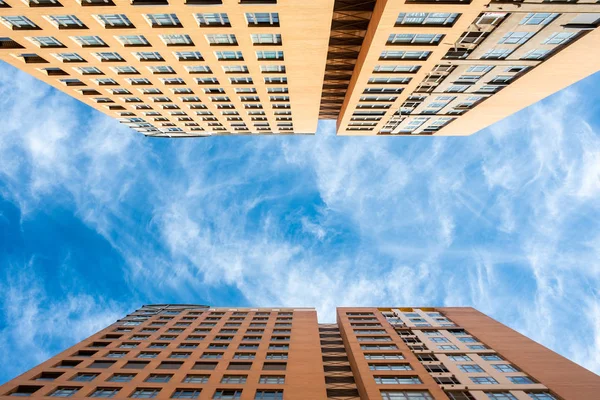 Vertical buildings of houses with blue sky background photographed from the ground.