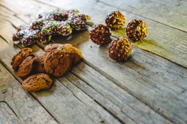 Küçük yaşlı ahşap panoları, Noel tatlılar ve fındık ile çikolata çikolata çikolata kurabiye yığını.