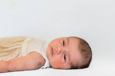 Onu yatakta yatarken ve kameraya bakarak oldukça yeni doğan kız portresi.