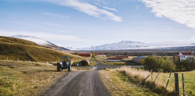 Çakıl yol çamur ile yağmurlu bir gün sonra İzlanda'nın karlı dağlarda