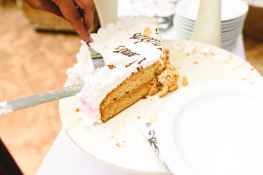 Düğün pastası için konuklar bir garson eliyle teslim dilimlenmiş.