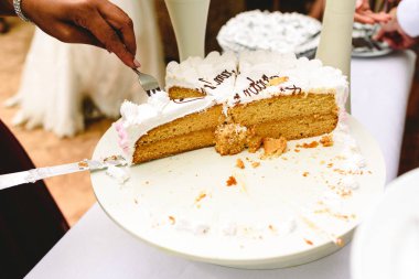 Düğün pastası için konuklar bir garson eliyle teslim dilimlenmiş.