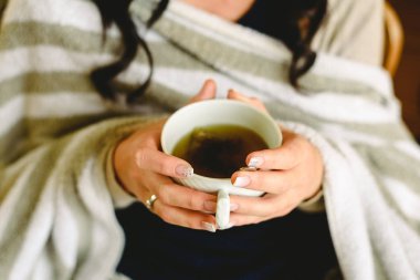 Genç kadın bir çay, bir fincan yakın çekim sahip.