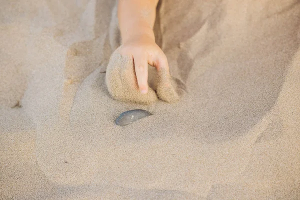 Mão Criança Pequena Apontando Uma Pedra Com Dedo Areia Praia — Fotografia de Stock