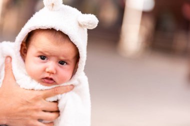Kulaklı bir kap giymiş kız bebek gülümseyen yüzünü.