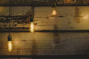 Üç sıcak renk koyu ahşap arka plan üzerinde Işık Ampüller dekorasyon.