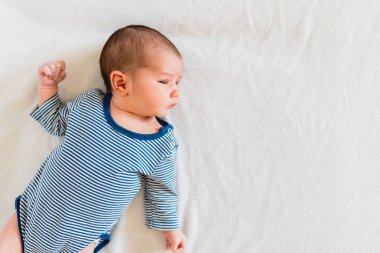 Onu yatakta yatarken ve kameraya bakarak oldukça yeni doğan kız portresi.