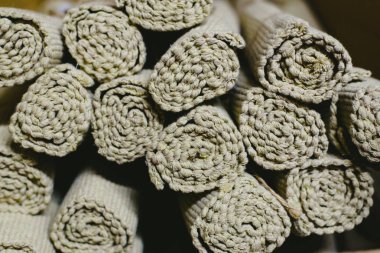 Bir depoda Satılık birçok kahverengi halı yerleştirilmiştir.