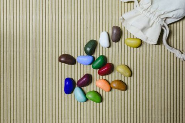 Arka plan bez poşet ile dalgalı bir kağıt üzerinde dağınık renkli sahte taş.