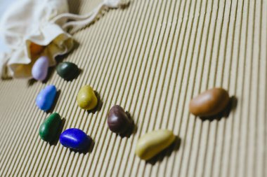 Arka plan bez poşet ile dalgalı bir kağıt üzerinde dağınık renkli sahte taş.