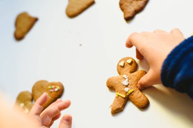 Ev yapımı gingerbread çerezleri renkli süslemeleri ile hazırlama çocuk eller.