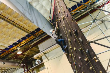 Korkularını aşmak için çocuk yukarı tırmanma duvarı tırmanışı.