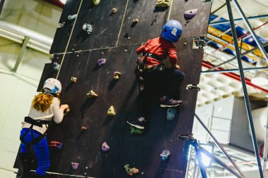 Valencia, İspanya - 4 Ocak 2019: kask ve halatlar ile güvenli bir tırmanma duvarı tarafından tırmanma iki çocuk.