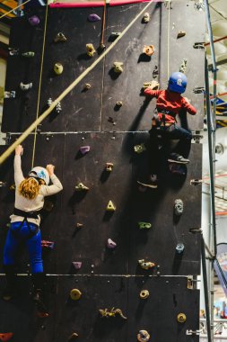 Valencia, İspanya - 4 Ocak 2019: kask ve halatlar ile güvenli bir tırmanma duvarı tarafından tırmanma iki çocuk.