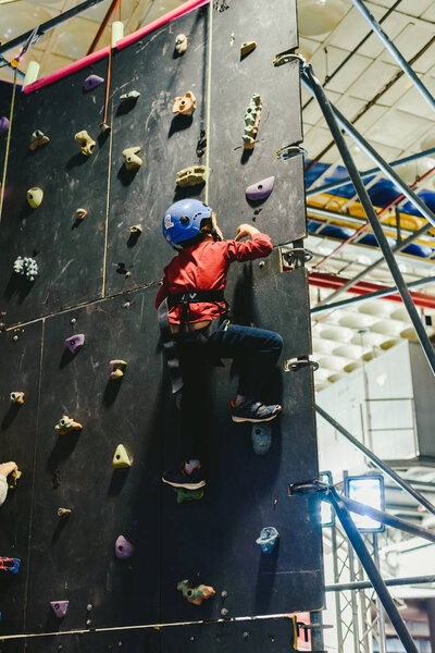 Валенсия, Испания - 4 января 2019 года: Мальчик взбирается на стену, защищенную шлемом и веревками
.
