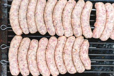 Birçok beyaz sosis mangal kömür ile kızartma için üst üste.