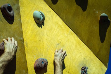 Dağcı'nın elleri açık bir tırmanma duvarı desteklerin bağlı.