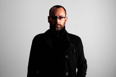 Ciddi kel orta yaşlı adam siyah montlu rötuşlanmamış portresi.