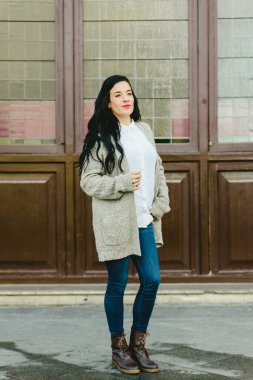 Kot pantolon ve zarif deri ile yün kazak güzel genç kadın botları, açık moda olduğu gibi poz.