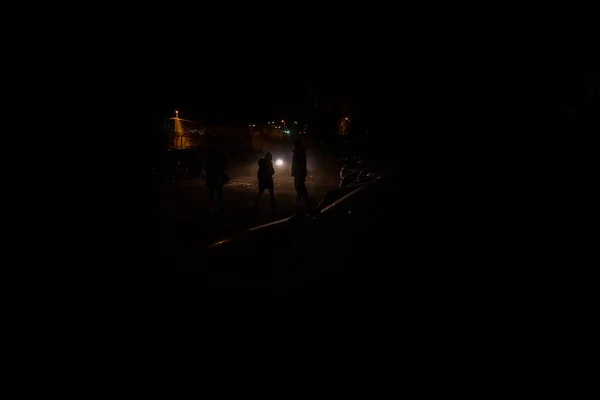 在一个黑暗的夜晚 无法辨认的人的剪影被汽车的大灯照亮 — 图库照片