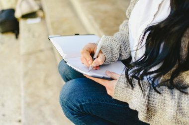 Kadın eli onun not defterinde oturan kalemle notlar almak.