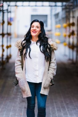 Gülümseyen ve mutlu bir şekilde yürürken kentin içinden gülerek orta yaşlı bir kadın.