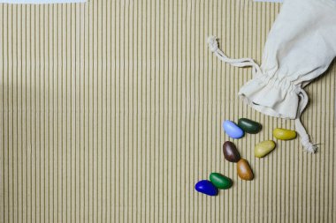 Arka plan bez poşet ile dalgalı bir kağıt üzerinde dağınık renkli sahte taş.