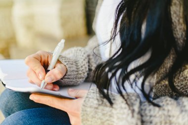 Kadın eli onun not defterinde oturan kalemle notlar almak.