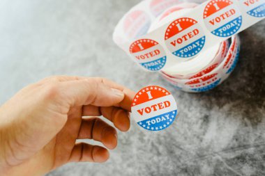 Amerikan seçimlerinin destekçisi çıkartmaları tutan adam el