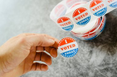 Man hand holding supporter stickers of american elections clipart