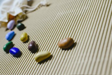 Arka plan bez poşet ile dalgalı bir kağıt üzerinde dağınık renkli sahte taş.