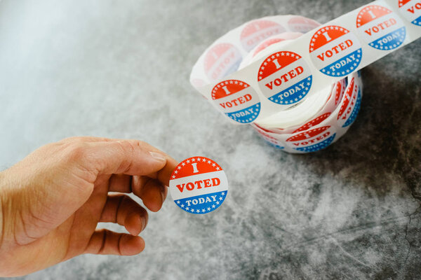 Рука человека учит, что он проголосовал сегодня на американских выборах с наклейкой
.